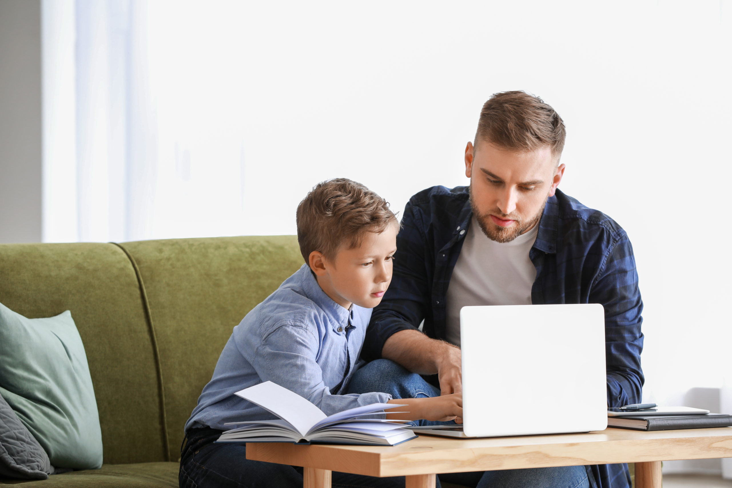 Man tutoring a young boy at home